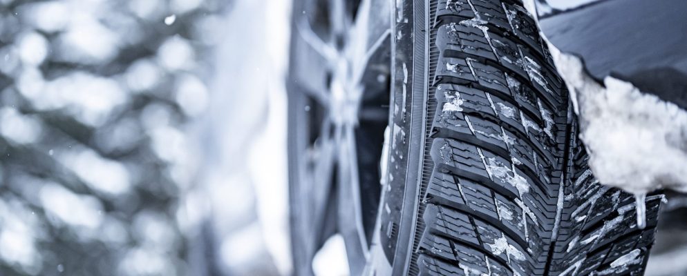 A close up of winter tires covered in snow